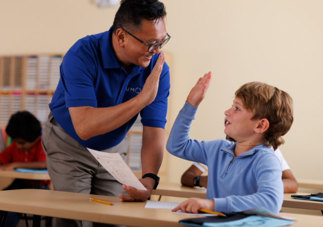 Instructor giving a high five as positive feedback for accomplishing their worksheet