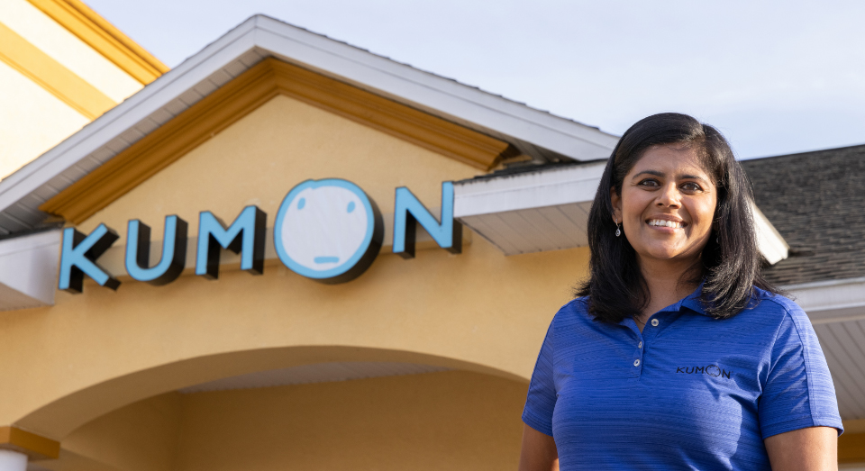 Learning center instructor poses for a photo in front of her location