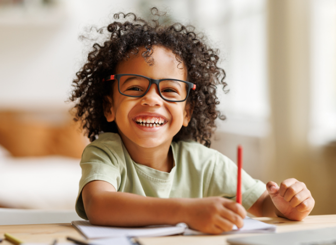 Student takes a break from working on worksheets to smile for the camera