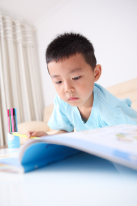 A young boy completes his homework independently