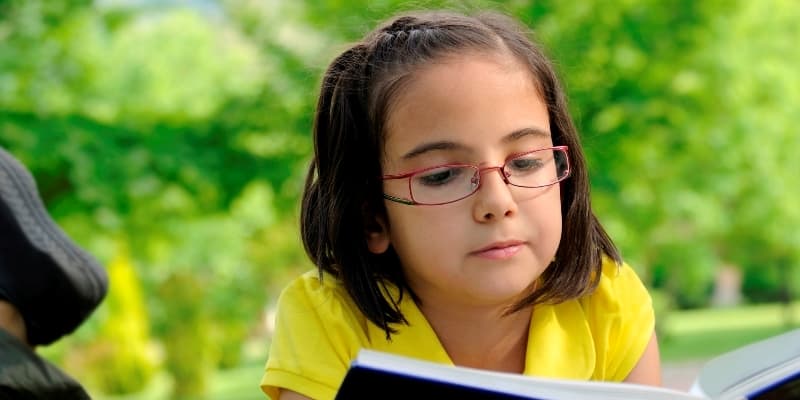 Student reading outside her summer reading and math programs