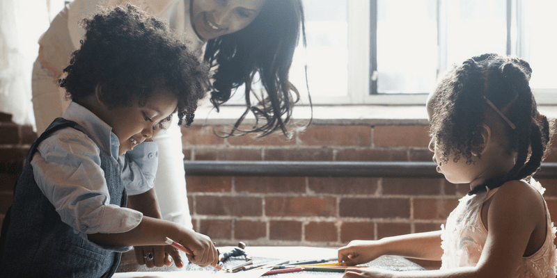 Children coloring with their mother