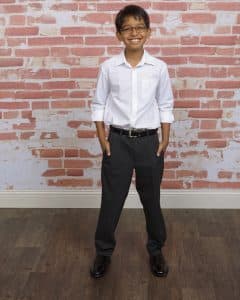 Arjun standing by a brick wall