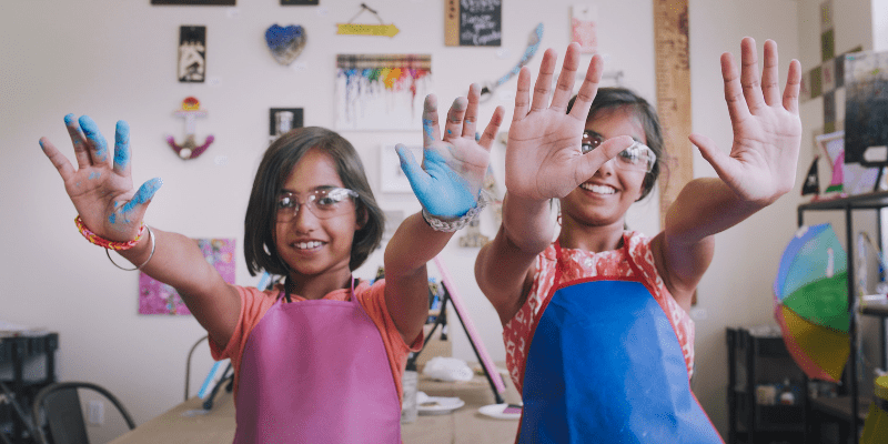 Reyshum and Naveen with paint on their hands