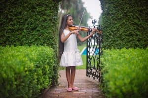 Agrini playing the violin in a garden