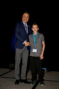 Kyler shakes hands with Kumon North America President Mino Tanabe