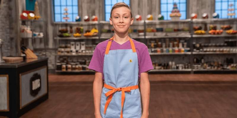 Davis stands in an apron on set