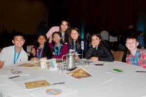 Suhani sits with a group of students at the Student Conference