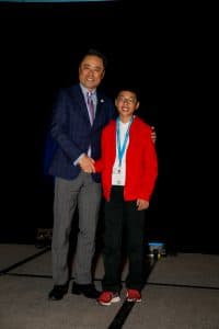 Nathan shakes hands with Kumon North America President Mino Tanabe
