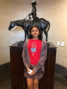 Suhani stands in front of a cowboy statue