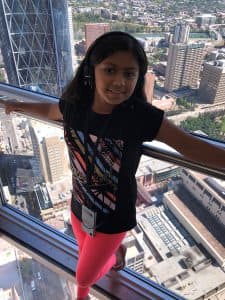 Suhani standing at an observation deck looking over Calgary