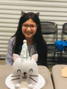 Zoha smiles as she celebrates her birthday with a cat-shaped cake.
