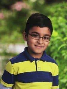 Abhinav poses for a photo in a yellow and blue shirt