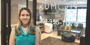 Laisa stands in front of the glass door leading to her Kumon Center