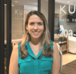 Laisa stands in front of the glass door leading to her Kumon Center