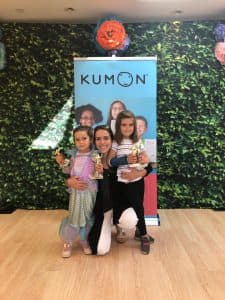 Laisa poses for a photo with her daughters at a Kumon Award Ceremony