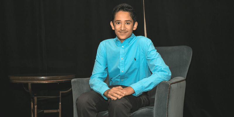 Pragun poses in a chair at the student conference