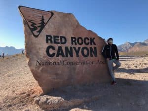 Pragun stands in front of a rock at Red Rock Canyon