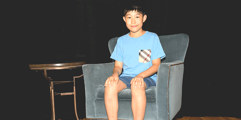Isaac poses in a chair at the student conference