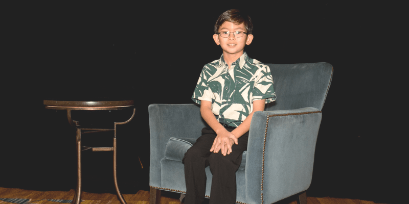 Jake poses in a chair at the student conference