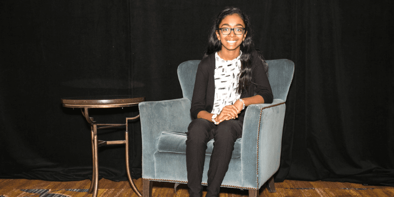 Varnica poses in a chair at the student conference