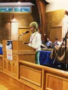 Amina speaks at a podium at a Kumon Award Ceremony