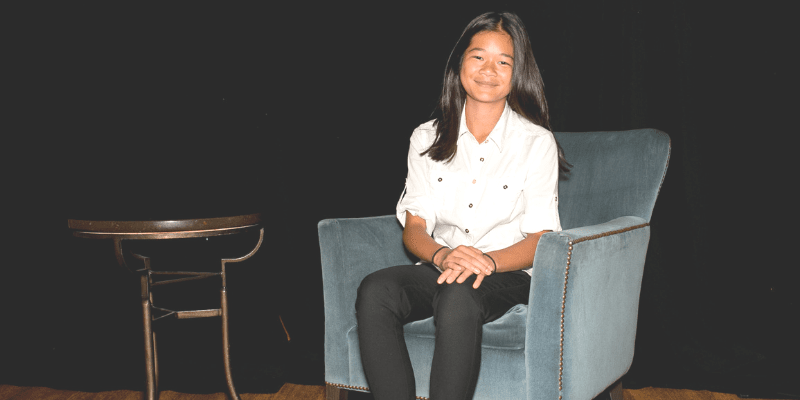 Hazel poses in a chair at the student conference