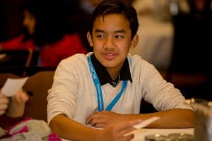 Joshua sits at a table at the student conference