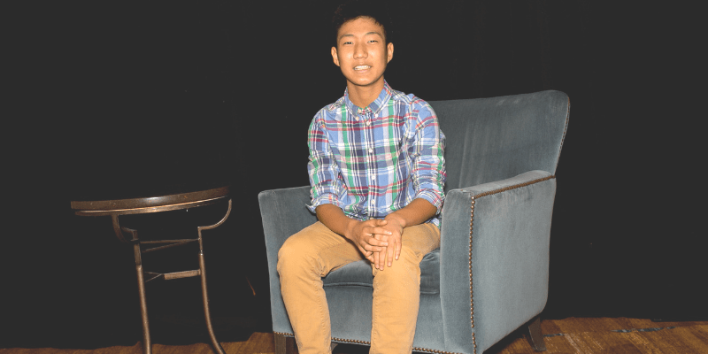 Ryan poses in a chair at the student conference