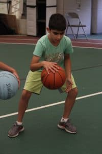 Rodean plays basketball in a green shirt and yellow shorts