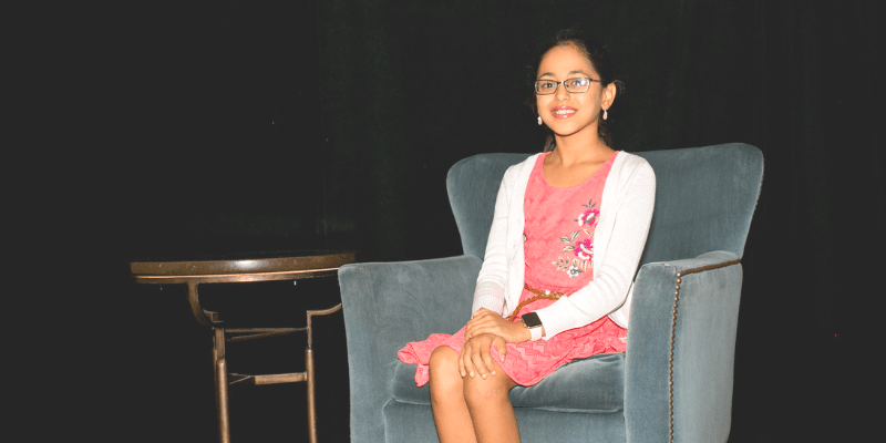 Asmita poses in a chair at the student conference