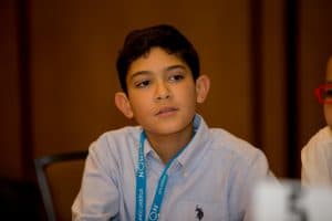 Nicholas gazes up while seated during a session at the student conference