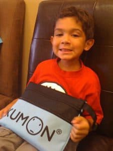Nicholas holds his Kumon bag as a young child