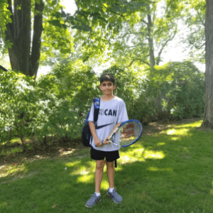 photo of student outside holding his tennis racket