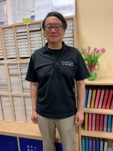 Sherman stands in front of worksheet shelves in his center