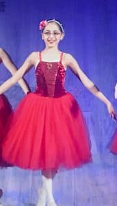 Asmita poses in a red costume during a ballet recital