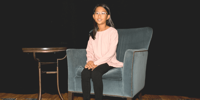 Anna sits in a chair at the student conference