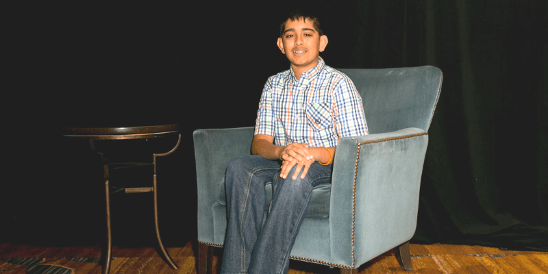 Ravi sits in a chair at the student conference