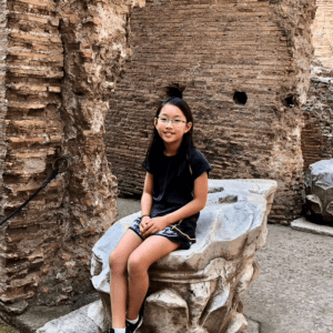 Anna sits in front of ancient ruins