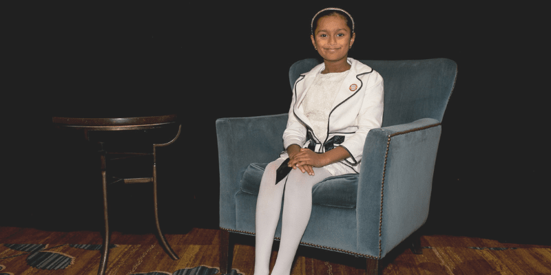 Ria sits on a chair at the student conference