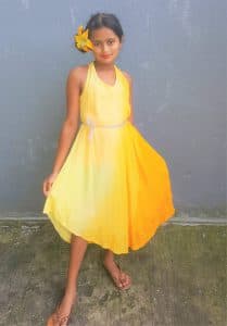 Ria poses in a yellow dress for a dance recital