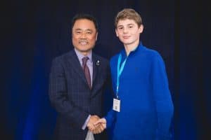 Aidan shakes hands with Kumon North America president Mino Tanabe