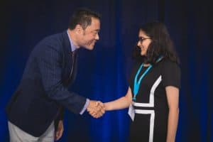 Vidhi shakes hands with Kumon North America president Mino Tanabe