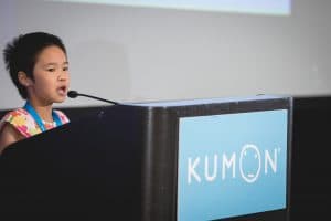 Alvina speaks at the podium at the student conference