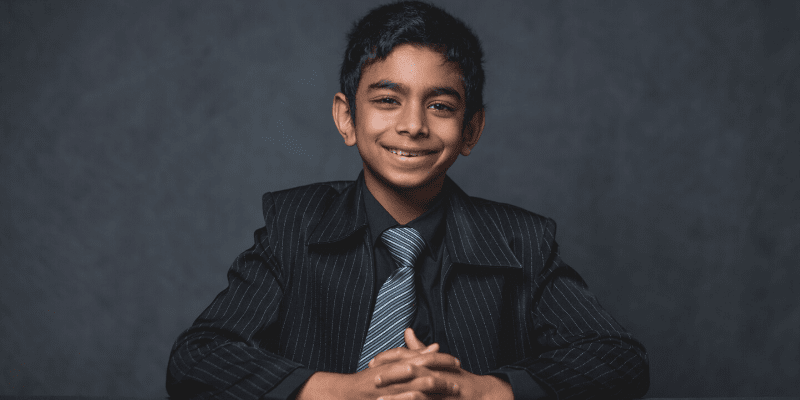 Aaron poses in front of a gray background at the student conference