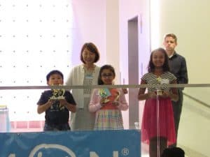 Aoi stands with students at an award ceremony