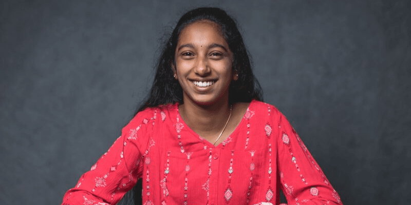 RIshika poses in front of a gray background
