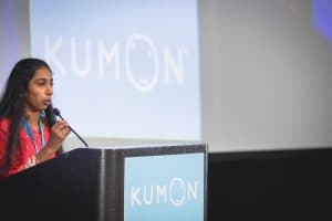 Rishika speaks at the podium at the student conference