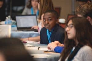 Temi sits at a table during the student conference