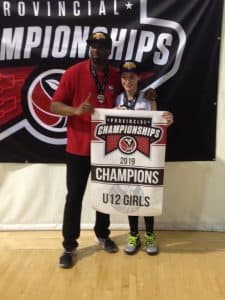 Ava holds a championship banner next to her coach